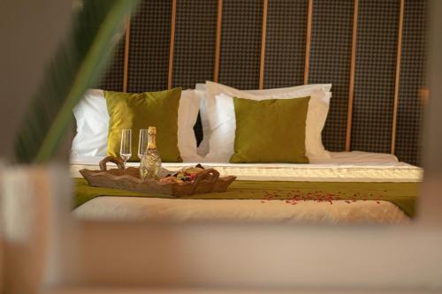 a bed with a table with bottles and glasses on it at La Piscine Art Hotel, Philian Hotels and Resorts in Skiathos Town