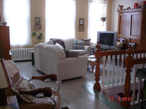 a living room with a couch and chairs and a tv at Le Gîte des Soeurs in Saint-Luc-de-Vincennes