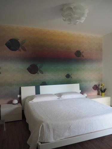 a bedroom with a bed with fish painted on the wall at Mami al Mare in Duino