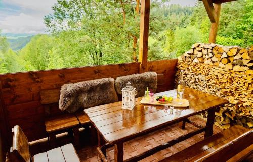 a porch with a wooden table and a couch at ZRUB BINDT in Hnilčík