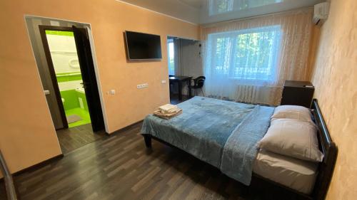 1 dormitorio con 1 cama, TV y ventana en Apartment in the center en Zhytomyr