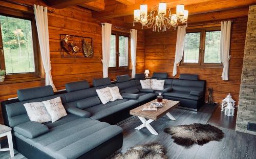 a living room with blue couches and a table at ZRUB BINDT in Hnilčík