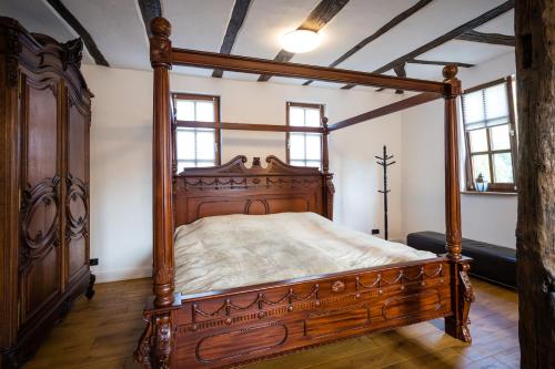 a bedroom with a wooden canopy bed in a room at Rißbacher Hof anno 1737 in Traben-Trarbach
