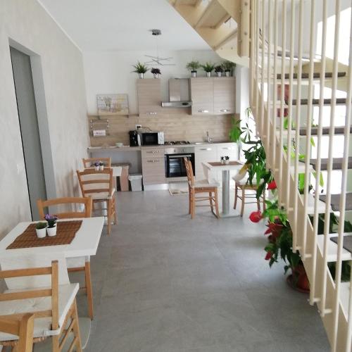 uma cozinha e sala de jantar com mesas e cadeiras em A casa di cinzia em Pineto