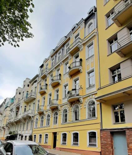 a yellow building with balconies on a street at Apartment Anglicka 138 in Mariánské Lázně