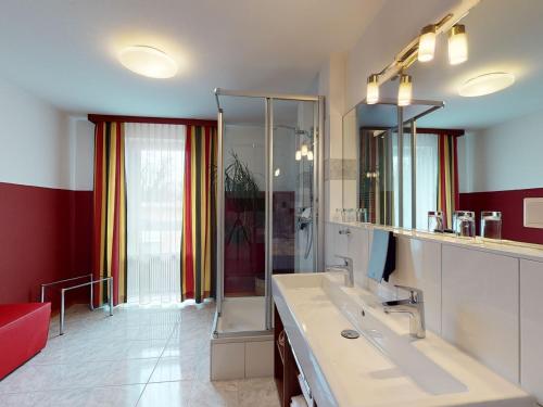 a bathroom with a sink and a glass shower at Hotel Via Roma in Salzburg