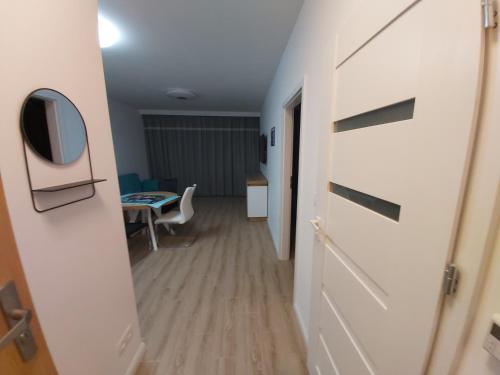 - un couloir avec une chambre dotée d'une table et d'un miroir dans l'établissement Przymorze Spectrum Apartment for you z halą garażową, à Gdańsk