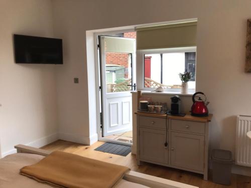 a room with a door open to a room with a table at The Retreat in Sheringham