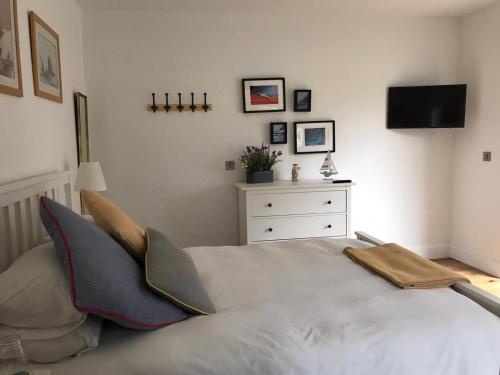 a bedroom with a bed and a dresser with a tv at The Retreat in Sheringham