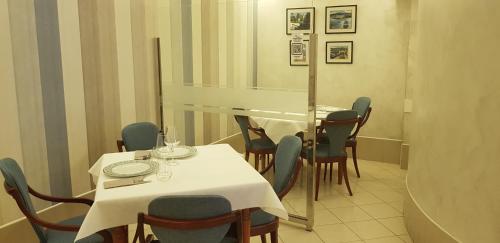 una sala da pranzo con tavolo e sedie bianchi di Pensión Elisardo a Noya