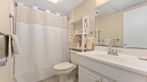 een witte badkamer met een toilet en een wastafel bij Adventurer Oceanfront Inn in Wildwood Crest