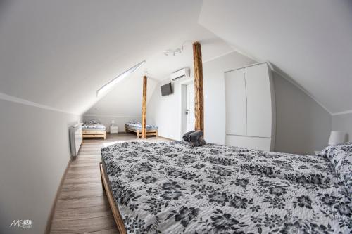 a bedroom with a bed with a black and white comforter at Domek u Mai in Zator