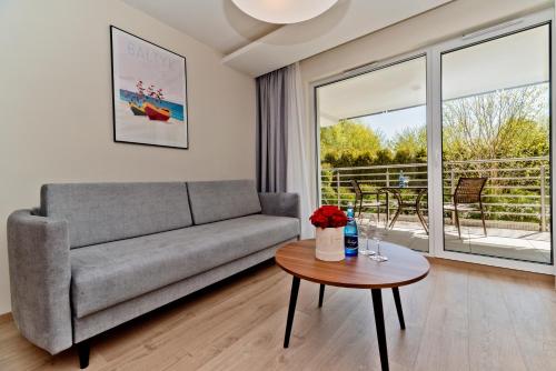 a living room with a couch and a table at BlueApart Apartamenty Na Klifie in Władysławowo