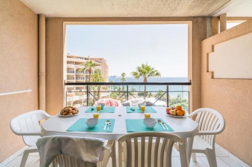 a dining room with a table and a large window at Résidence La Palme d'Azur Cannes Verrerie in Cannes