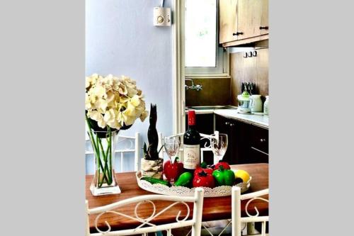 una cucina con tavolo e bottiglie di frutta e vino di Nikoleta Apartment a Chania