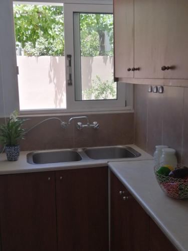 a kitchen with two sinks and a window at Nikoleta Apartment in Chania