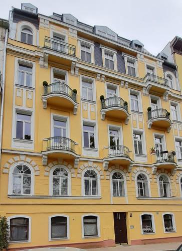 a yellow building with windows and balconies at Apartment Anglicka 138 in Mariánské Lázně