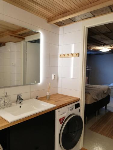 a bathroom with a washing machine and a sink at Tyynynpaikka in Tampere