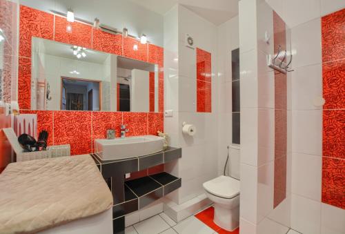 W łazience znajduje się umywalka, toaleta i lustro. w obiekcie Apartamenty BIESZCZADZKI Anioł w mieście Ustrzyki Dolne