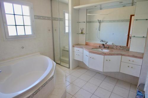 une salle de bain blanche avec une baignoire et un lavabo dans l'établissement Domaine de l'oasis, aux Arcs-sur-Argens