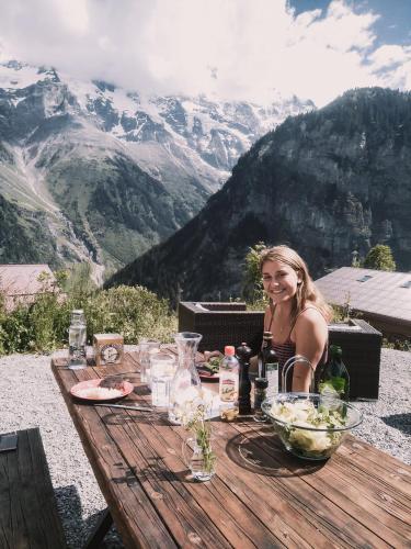 a woman sitting at a table with a bowl of food at Mountain Hostel Gimmelwald in Gimmelwald