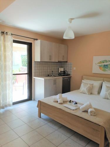 a bedroom with a large bed and a kitchen at Nini's House 1 Nydri - 100m from beach NYDRI TOWN CENTER in Nydri