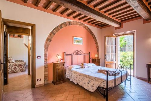 a bedroom with a bed and an archway at Agriturismo Oliviera Winery & Hiking in Vagliagli