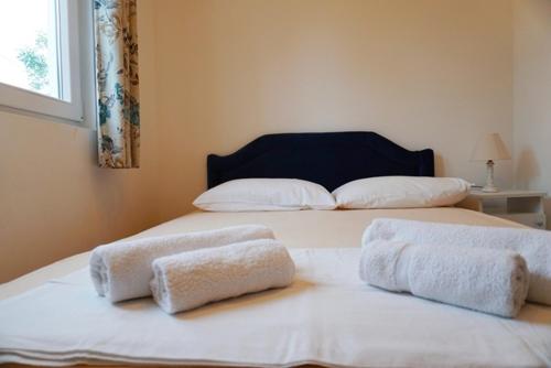 two white towels on two beds in a room at Apartmani M&E in Tivat