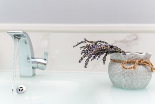 a vase with a plant in it next to a sink at Čikat bay residence in Mali Lošinj