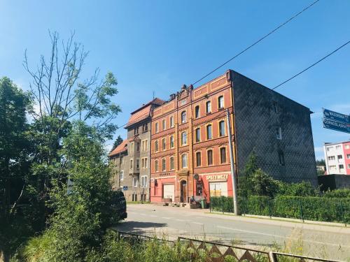 un gran edificio de ladrillo en el lateral de una calle en Apartament Sienkiewicza, en Głuszyca