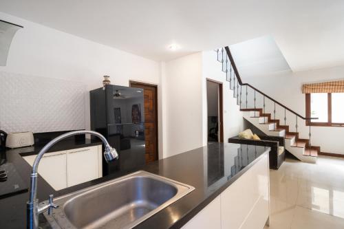 a kitchen with a sink and a staircase at Villa Whitney in Lamai