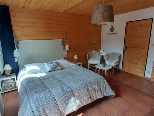 um quarto com uma cama, uma mesa e cadeiras em Les chambres du Presbytère du Val em Valdeblore
