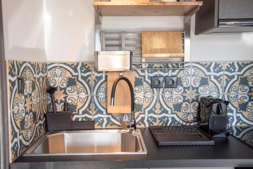 cocina con fregadero de acero inoxidable y papel pintado con motivos florales en Urban Sea View Lofts #1, en Chalkida