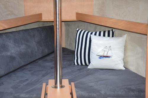 a bed with a white pillow with a sailboat on it at Phobos 24,5 Yacht in Polańczyk
