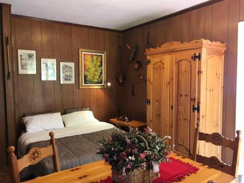 - une chambre avec un lit et un mur en bois dans l'établissement Limonetto dream, à Limone Piemonte