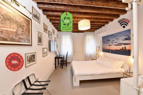 Schlafzimmer mit einem Bett, einem Tisch und Stühlen in der Unterkunft Sottopiano - comfort in the center in Venedig