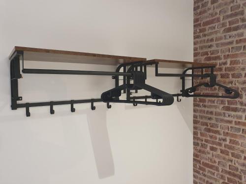 a black metal shelf hanging from a brick wall at The Snug Bourne in Bourne