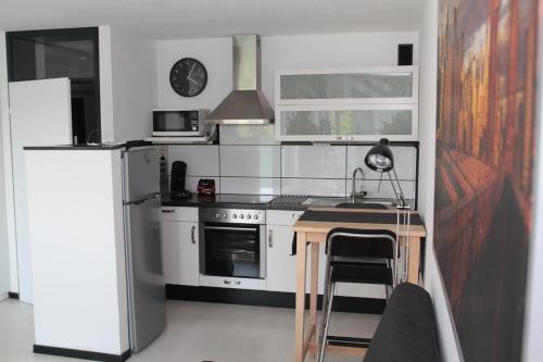 eine Küche mit einem Kühlschrank und einem Tisch darin in der Unterkunft 1-Zimmer Business Appartement in Worms