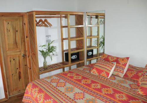 a bedroom with a bed and a wooden cabinet at Hotel Posada Seremein ,West Bay ,Roatan in West Bay