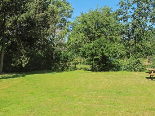 einen Park mit einer Holzbank auf einem Grasfeld in der Unterkunft 4 person holiday home in Dannemare in Dannemare