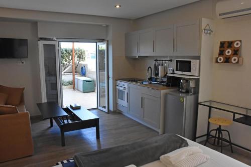 a kitchen and living room with a couch and a table at Seaside Studio Meltemi in Rafina