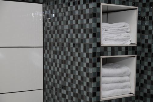 une salle de bains avec deux miroirs et des serviettes sur un mur carrelé dans l'établissement 1-Zimmer Business Appartement, à Worms