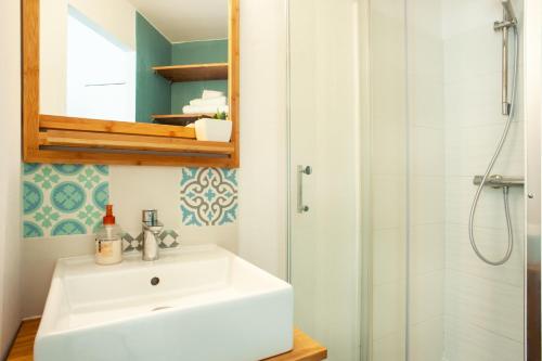 a bathroom with a white sink and a shower at Les Douces Breizh - Jules Ferry - Proximité Gare SNCF in Saint-Brieuc