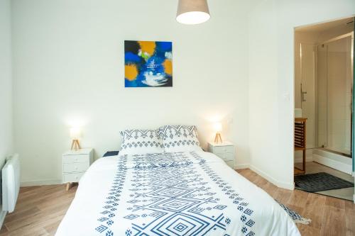 a bedroom with a white bed with a blue and white bedspread at Les Douces Breizh - Jules Ferry - Proximité Gare SNCF in Saint-Brieuc