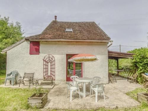 una casa con mesa, sillas y sombrilla en Country house near Canal du Nivernais, en Devay