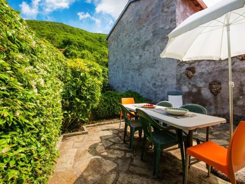 a table and chairs with an umbrella on a patio at Belvilla by OYO Casa Pascoso in Pescaglia