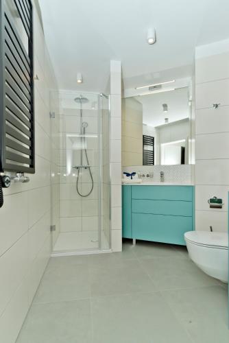a bathroom with a shower and a toilet and a sink at BlueApart Apartamenty Na Klifie in Władysławowo