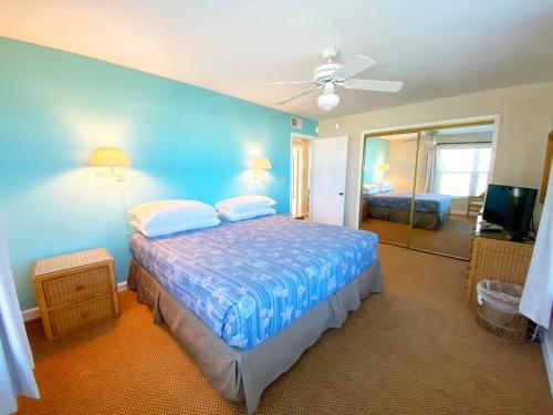 1 dormitorio con cama y pared azul en Camelot by the Sea en St Pete Beach