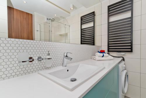 a bathroom with a sink and a mirror at BlueApart Apartamenty Na Klifie in Władysławowo
