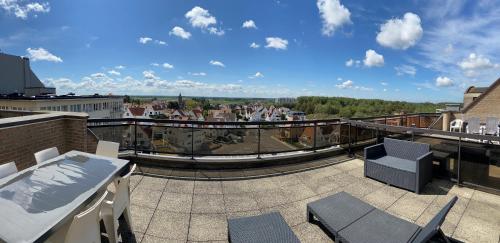 a balcony with chairs and a view of a city at Apartment Bel-Air in Knokke-Heist